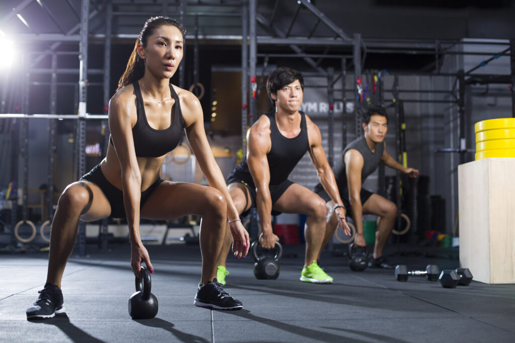 Young athletes training with kettlebells in crossfit gym